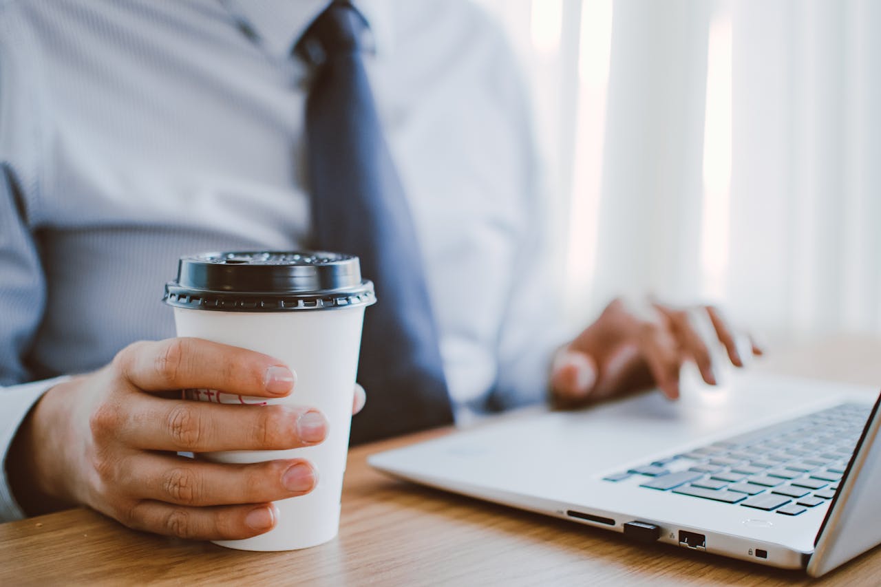 home-hero Business professional working remotely, enjoying coffee while using a laptop indoors.